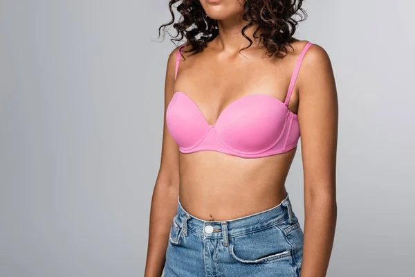 Cropped view of african american woman in pink bra standing isolated on grey — Stock Photo