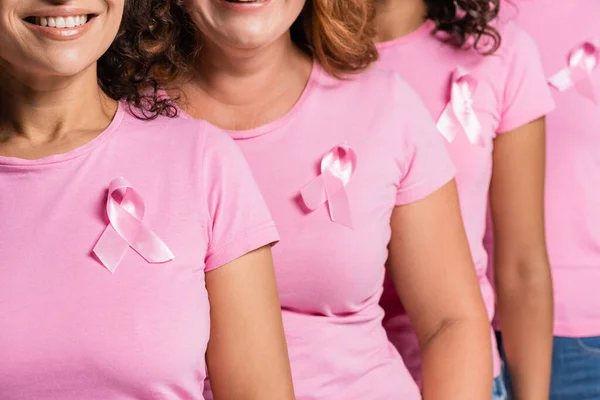 Cropped view of smiling multiethnic women with ribbons on t-shirts isolated on grey — Stock Photo