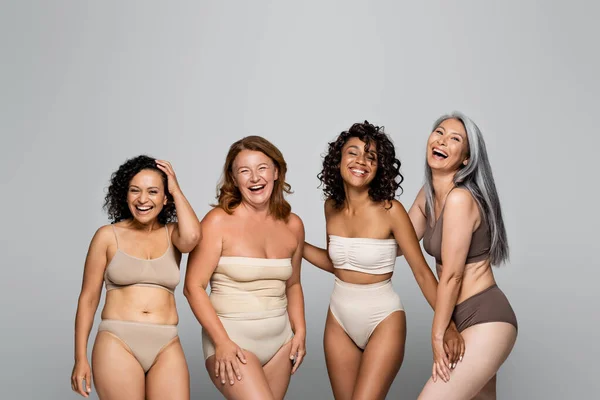 Cheerful multicultural body positive women in lingerie isolated on grey — Stock Photo