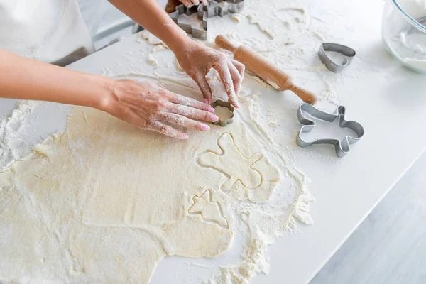 Partial view of woman cutting raw dough with cookie cutters — Stock Photo