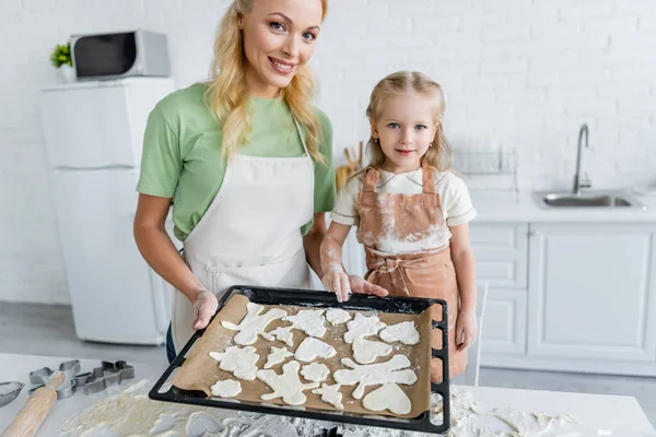 Heureux mère et fille tenant plaque à pâtisserie avec brut multi cookies en forme — Photo de stock