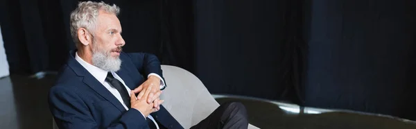 Geschäftsmann im Anzug sitzt während Talkshow auf Sessel, Transparent — Stockfoto