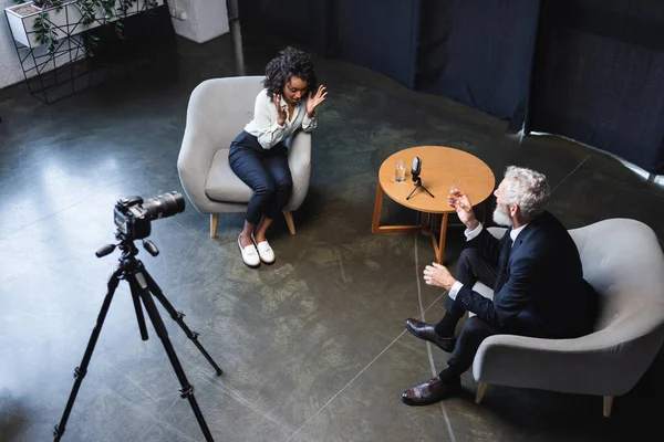 High angle view of african american journalist talking with guest in interview studio — Stock Photo