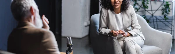 Vista recortada de feliz jornalista afro-americano conversando com empresário turvo durante entrevista, banner — Fotografia de Stock