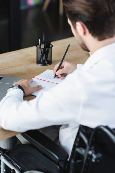 Desfocado empresário deficiente escrever com lápis no caderno — Fotografia de Stock