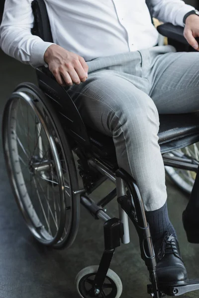 Teilsicht auf behinderten Geschäftsmann, der im Rollstuhl im Büro sitzt — Stockfoto