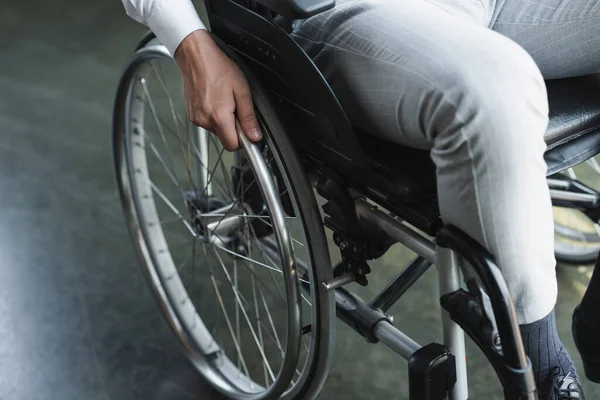 Cropped view of young handicapped businessman sitting in wheelchair — Stock Photo