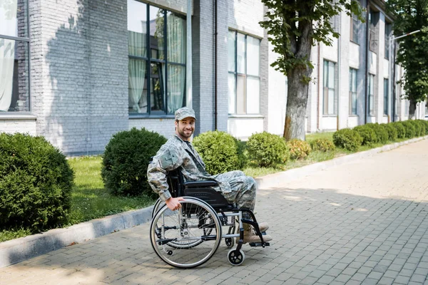 Junger behinderter Veteran im Rollstuhl lächelt auf der Stadtstraße — Stockfoto