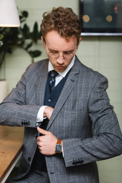 Hombre de negocios confiado en ropa formal mirando el bolsillo interior de la chaqueta - foto de stock