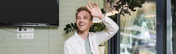 Positive man waving hand and looking away in cafe, banner — Stock Photo