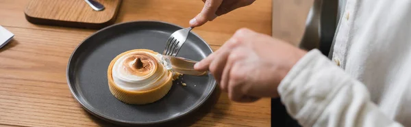 Vista recortada del hombre sosteniendo cubiertos cerca de tarta de limón en el plato, pancarta - foto de stock