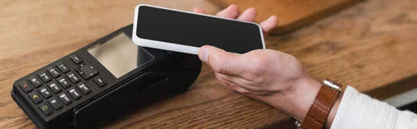 Cropped view of man paying with smartphone in cafe, banner — Stock Photo