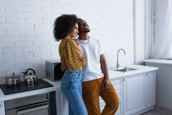Позитивная африканская пара, стоящая на кухне — стоковое фото