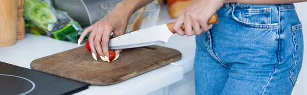 Vista ritagliata di donna che taglia pomodorini ciliegini in cucina, banner — Foto stock