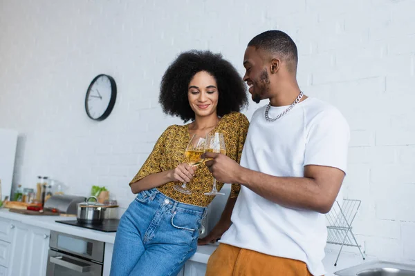 Sorridente donna afroamericana brindare vino con fidanzato a casa — Foto stock