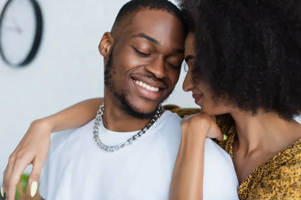 Jovem afro-americana abraçando namorado em casa — Fotografia de Stock