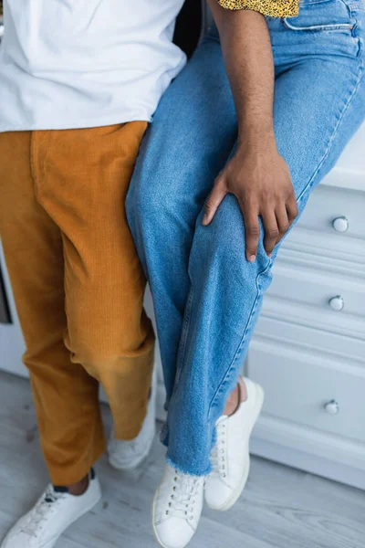 Cropped view of african american man touching knee of girlfriend — Stock Photo