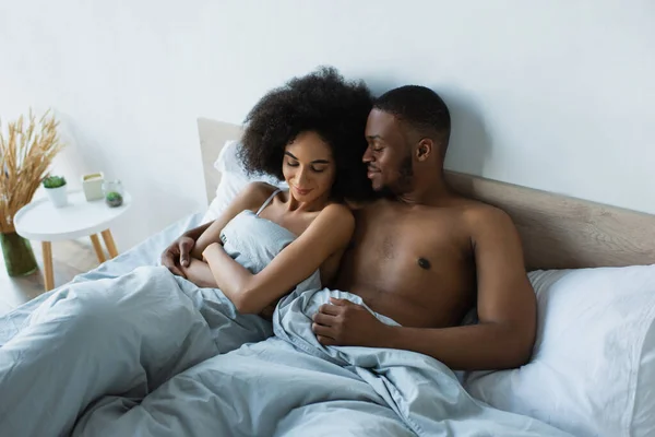 Afroamerikaner umarmt Freundin im Schlafzimmer — Stockfoto