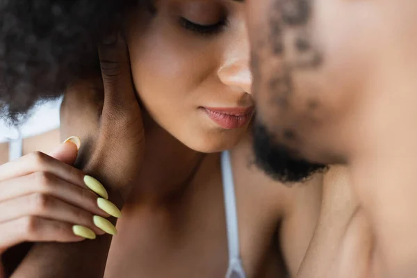 Desfocado afro-americano homem tocando namorada em casa — Fotografia de Stock