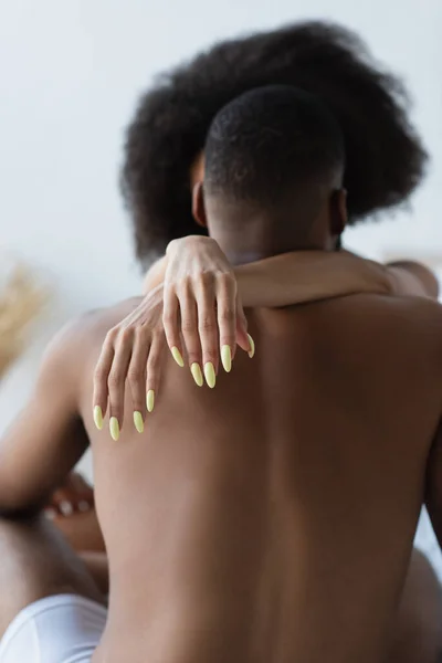 Mulher americana africana desfocada abraçando namorado sem camisa — Fotografia de Stock