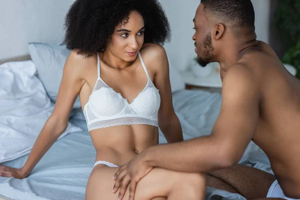 African american man touching sensual girlfriend on bed — Stock Photo