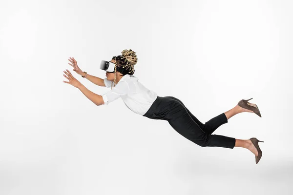 Боковой вид молодой африканской бизнесвумен, летящей в гарнитуре, изолированной на белом — стоковое фото