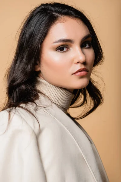 Young and pretty model in turtleneck looking at camera isolated on beige — Stock Photo