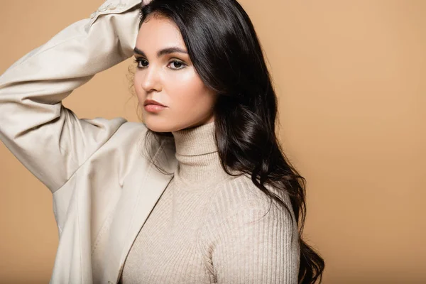 Young woman in turtleneck and blazer looking away isolated on beige — Stock Photo