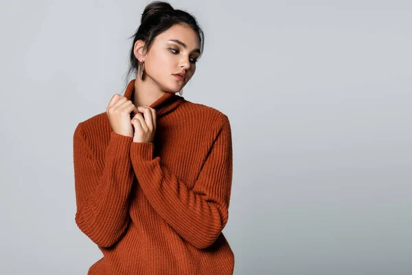 Jeune femme en pull tricoté regardant loin isolé sur gris — Photo de stock