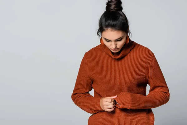 Jeune femme en pull tricoté regardant vers le bas isolé sur gris — Photo de stock