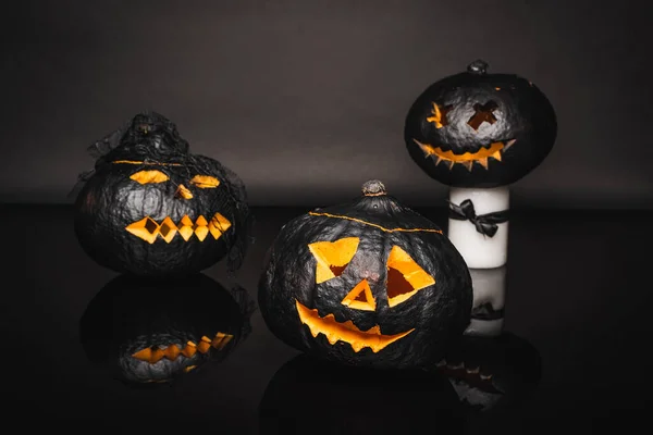 Creepy dark and curved pumpkins on black — Stock Photo