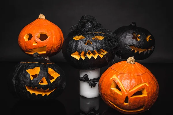 Calabazas talladas y espeluznantes sobre fondo negro - foto de stock