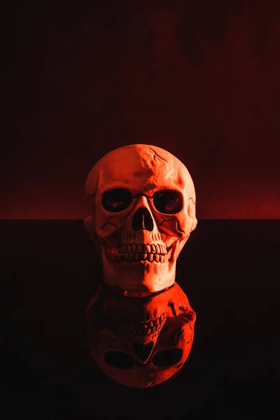 Red lighting on creepy skull on dark background — Stock Photo