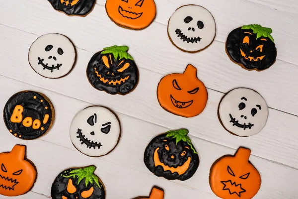 Vista superior de galletas espeluznantes y sabrosas de halloween en la superficie blanca - foto de stock