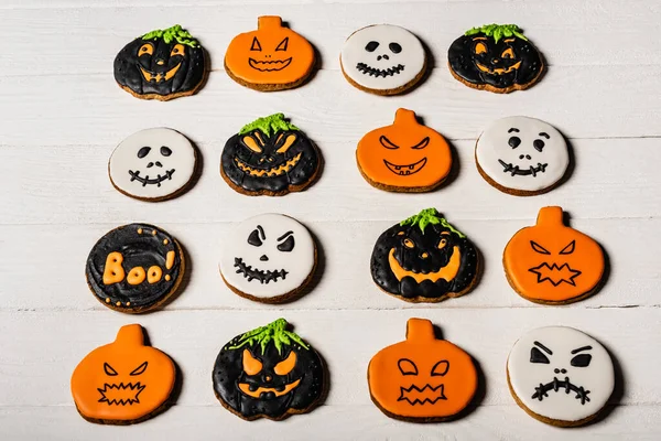 Vista de ángulo alto de galletas de halloween caseras y espeluznantes en la superficie blanca - foto de stock