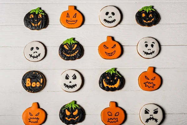 Vista superior de biscoitos de gengibre doces e assustadores na superfície branca — Fotografia de Stock