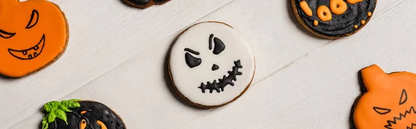 Верхний вид сладкий и жуткий Хэллоуин печенье на белой поверхности, баннер — стоковое фото