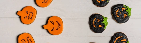 Vue du dessus des biscuits halloween en forme de citrouille douce et effrayante sur la surface blanche, bannière — Photo de stock