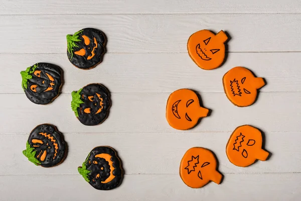 Top view of homemade and spooky pumpkin shape halloween cookies on white surface — Stock Photo