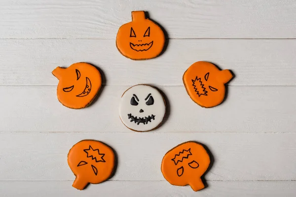 Flay lay with homemade and spooky pumpkin shape halloween cookies on white surface — Stock Photo