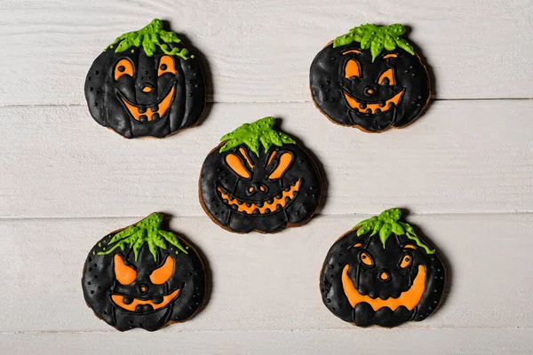 Flay mit schwarzer und gruseliger Kürbisform Halloween-Plätzchen auf weißer Oberfläche — Stockfoto