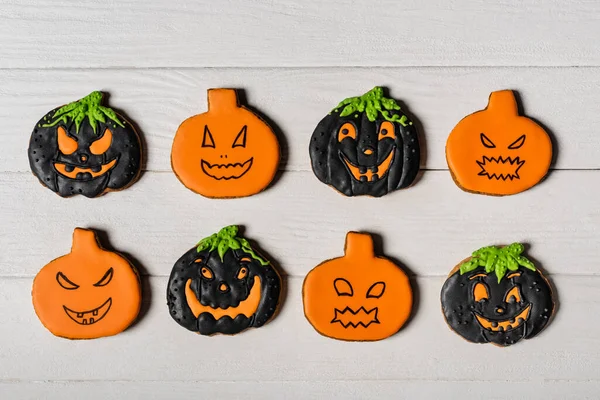 Flay lay with spooky pumpkin shape halloween cookies on white surface — Stock Photo