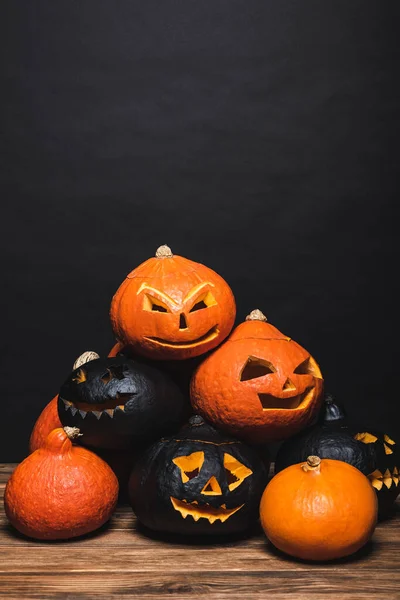 Stack of creepy halloween pumpkins on black — Stock Photo