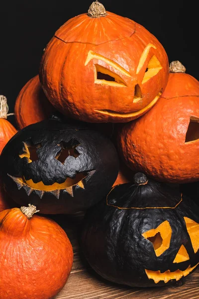 Pila de calabazas talladas y espeluznantes aisladas en negro - foto de stock