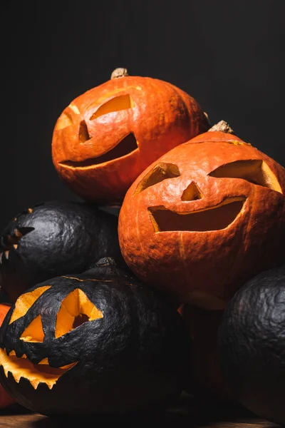 Stack of carved and creepy pumpkins isolated on black — Stock Photo