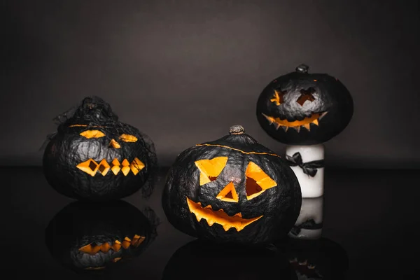 Carved and dark halloween pumpkins on black background — Stock Photo