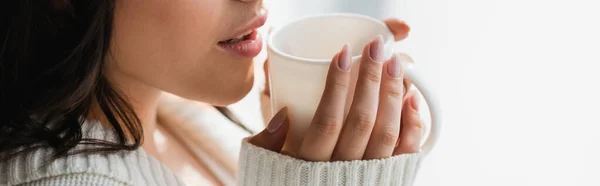 Partial view of woman in cozy clothes drinking warm tea, banner — Stock Photo