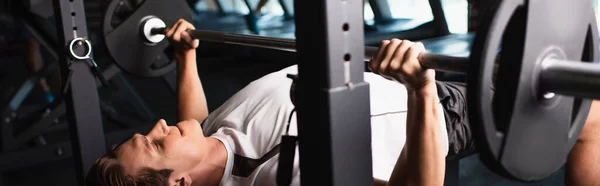 Homme athlétique travaillant sur la machine d'exercice d'haltérophilie, bannière — Photo de stock