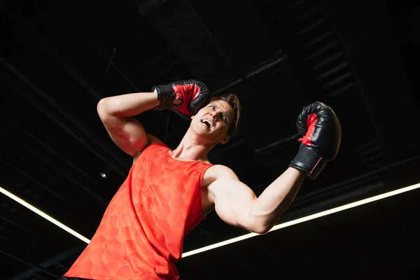 Low angle view of boxer screaming while training in sports center — Stock Photo