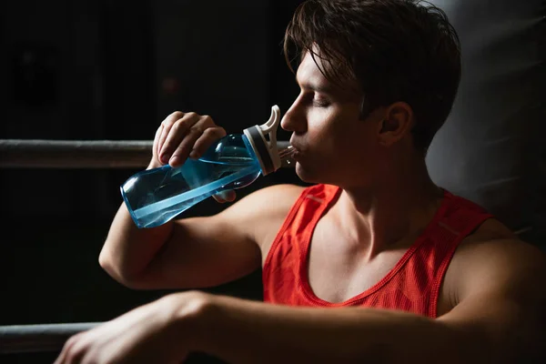 Thirsty sportsman drinking water from sports bottle with closed eyes — Stock Photo